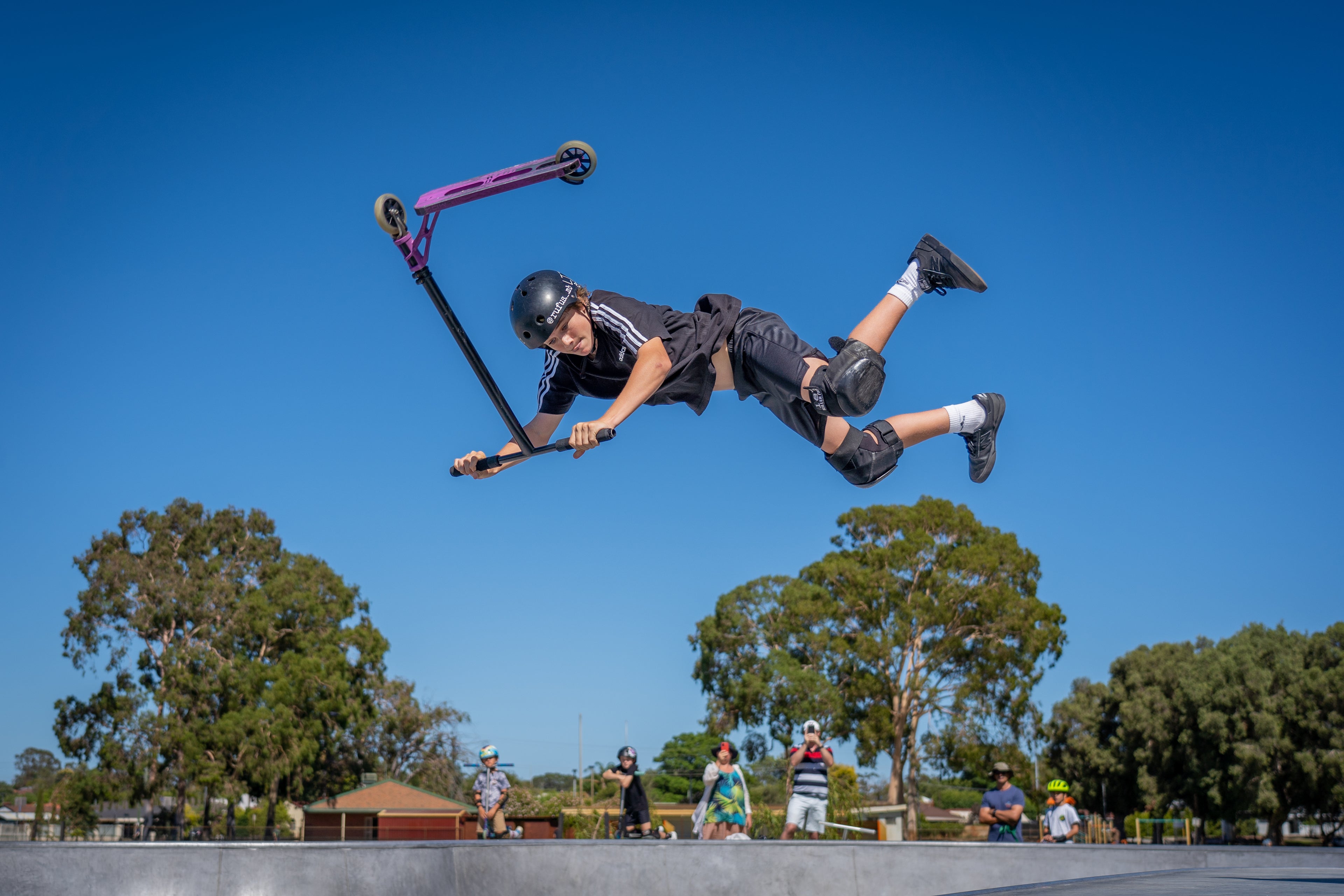 Big air scooter trick in big blue sky
